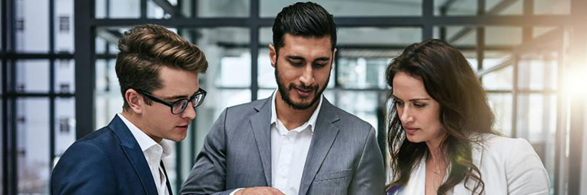 Fotografía personas mirando una tablet en la oficina.