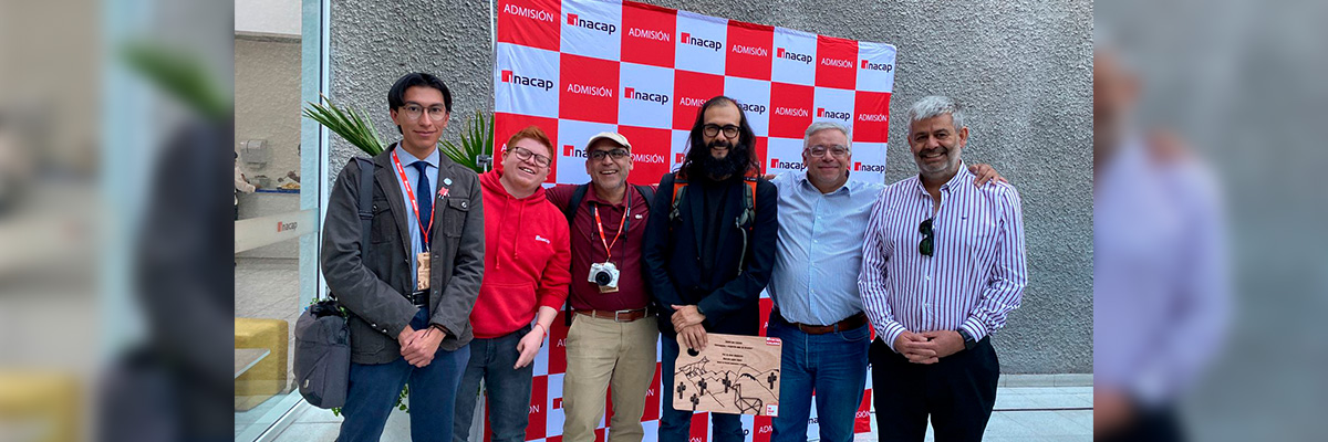 Hombres posando felices con Marcelo Lagos en visita a Sede INACAP Calama
