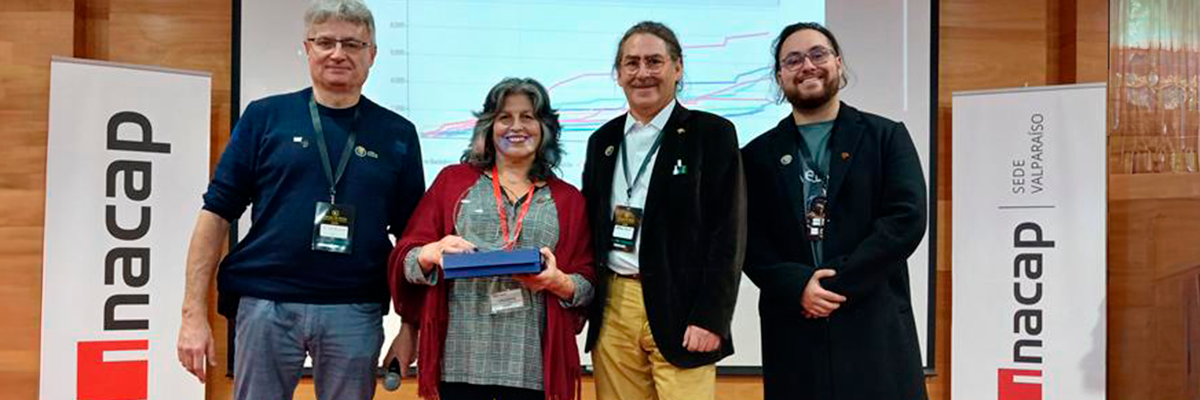 Lidia Herrera recibiendo el reconocimiento junto al equipo organizador de