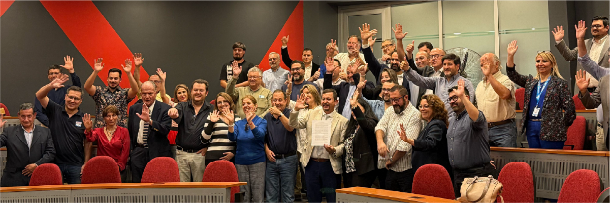 Tras firma participantes de la asamblea de la primera cámara de comercio macul posan y sonríen frente a la cámara