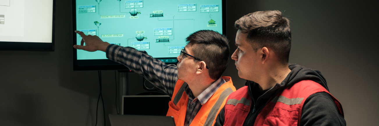 2 alumnos de INACAP señalando el computador