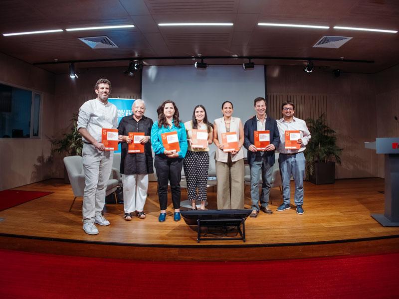 autoridades en el escenario con estudio impreso en la mano