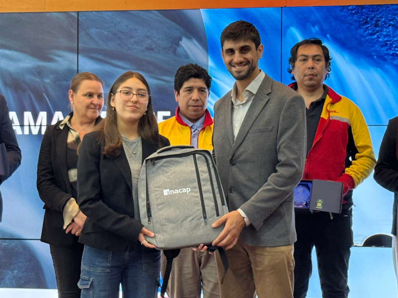 Felipe Riffo (subdirector programas aprendizaje) hace entrega de regalo simbólico a estudiante participante